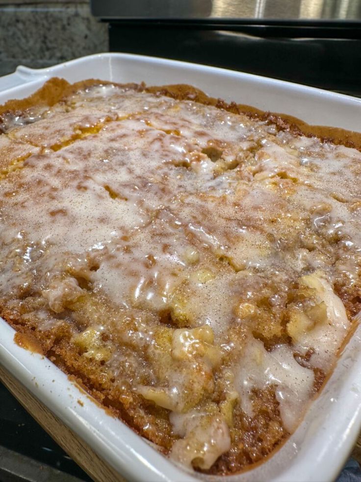 a casserole dish filled with meat covered in gravy sitting on top of a stove