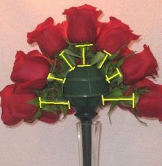 a vase filled with red roses on top of a table