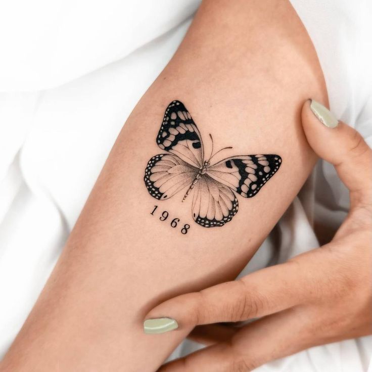 a woman's arm with a butterfly tattoo on it