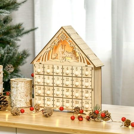 a wooden house with christmas decorations and candles on a table in front of a christmas tree