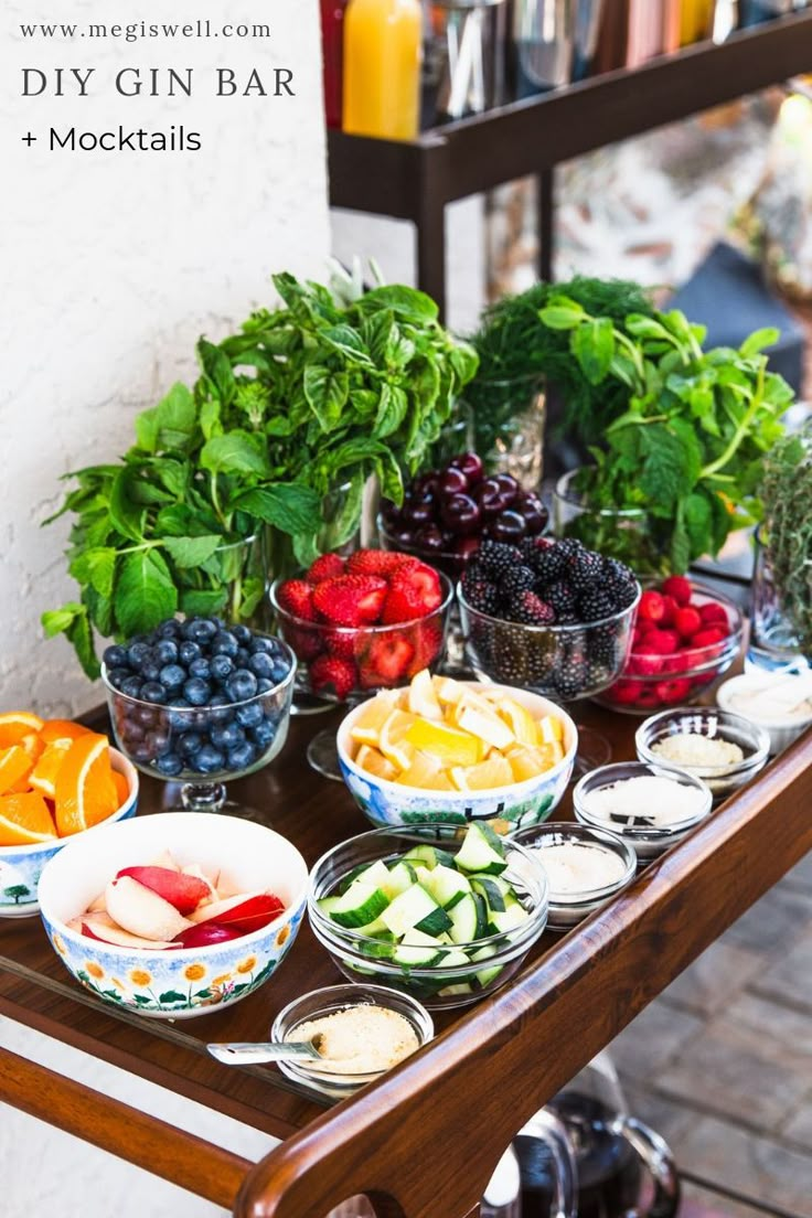 a wooden table topped with bowls of fruit and veggies next to a wall