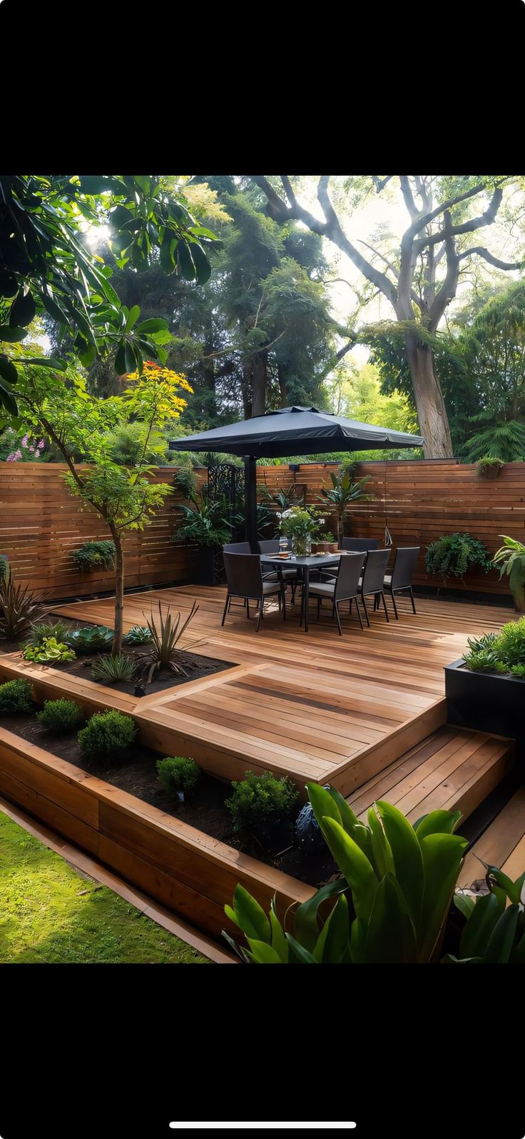 a wooden deck surrounded by plants and trees