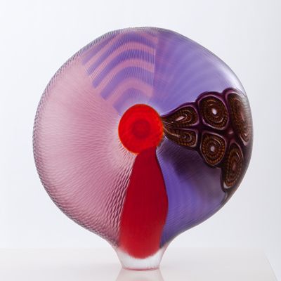 a purple and red vase sitting on top of a white table