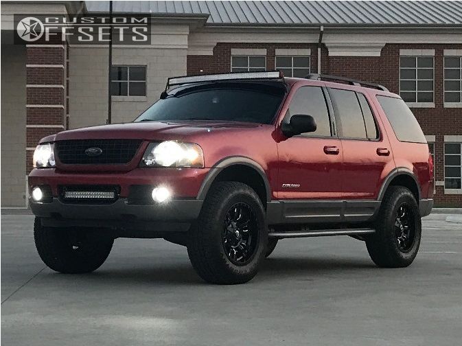 a red suv parked in front of a building