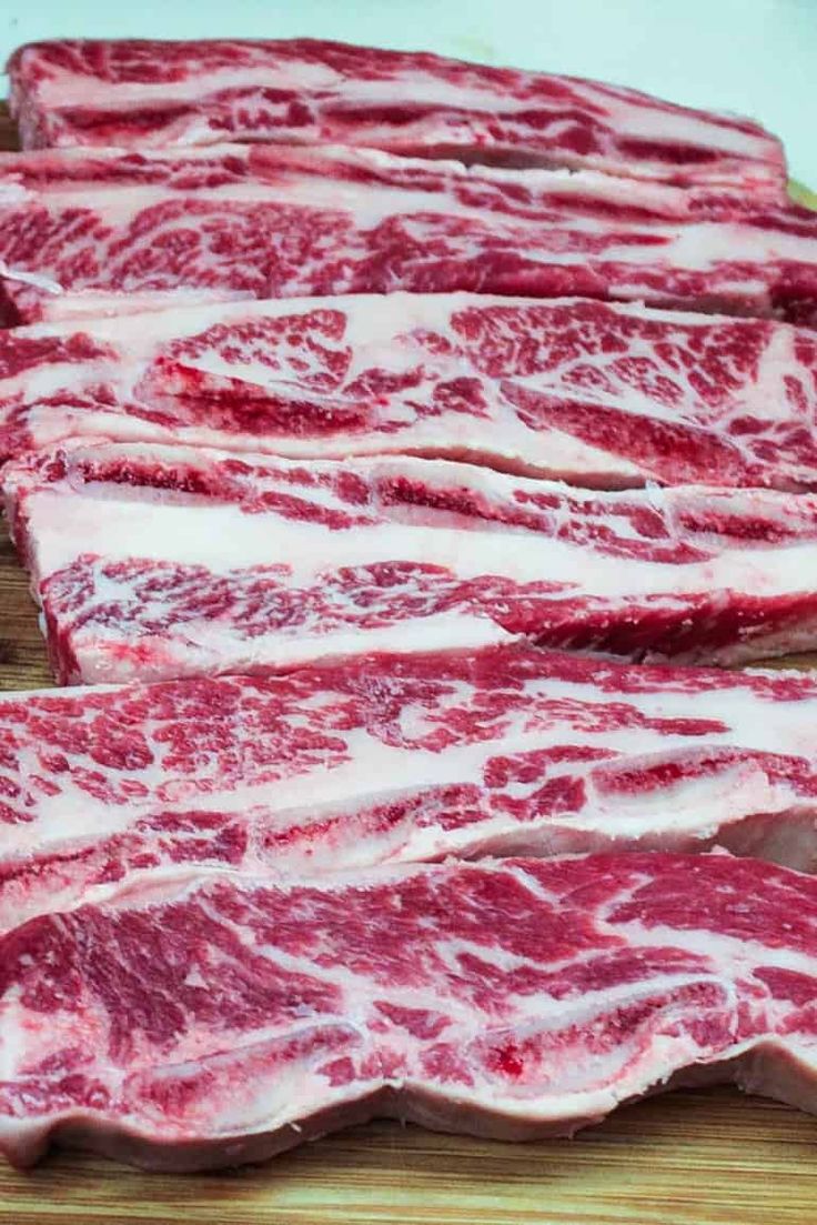 raw meat on a cutting board ready to be cut into smaller pieces and put in the oven