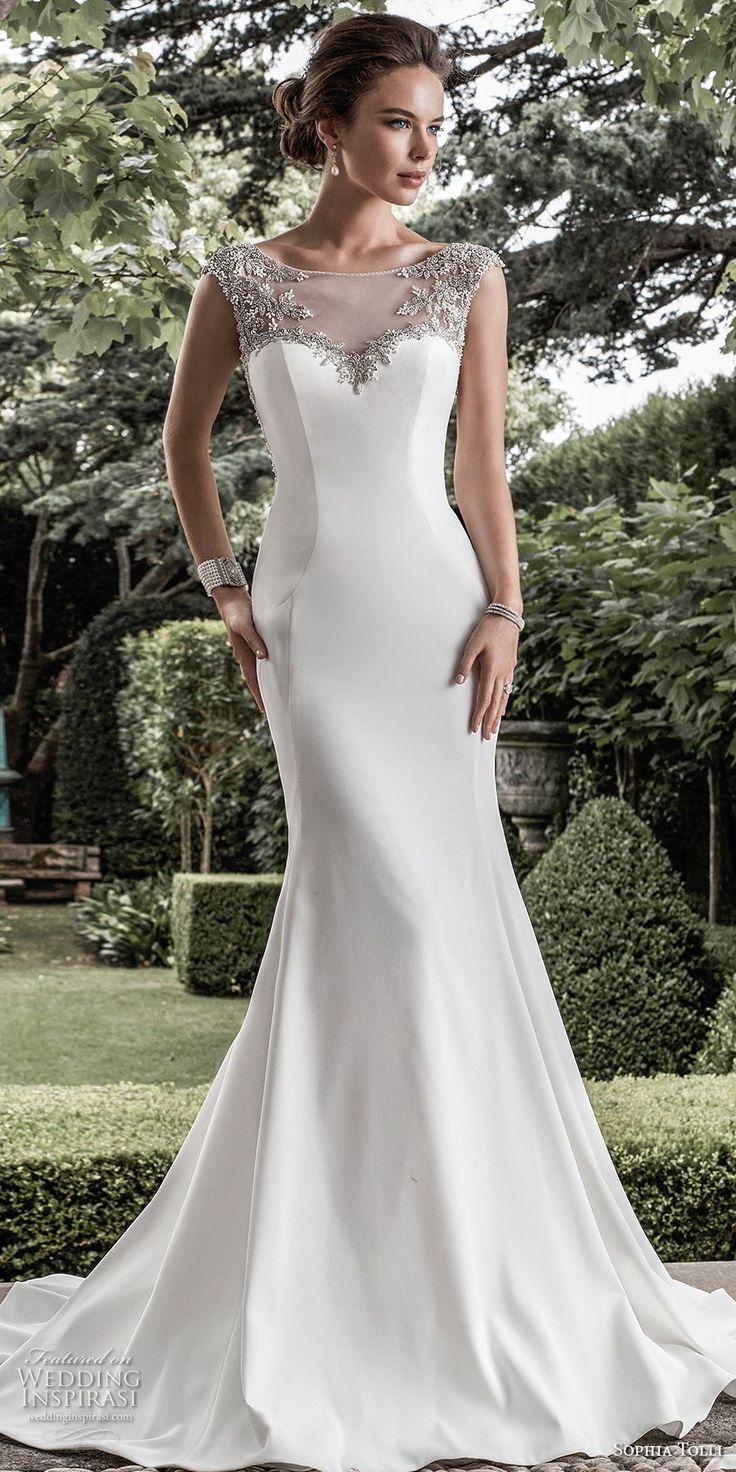 a woman in a white wedding dress standing on a stone walkway with her hands on her hips