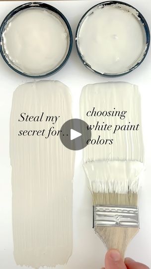 someone is painting white paint on the wall with two brushes and one can be seen