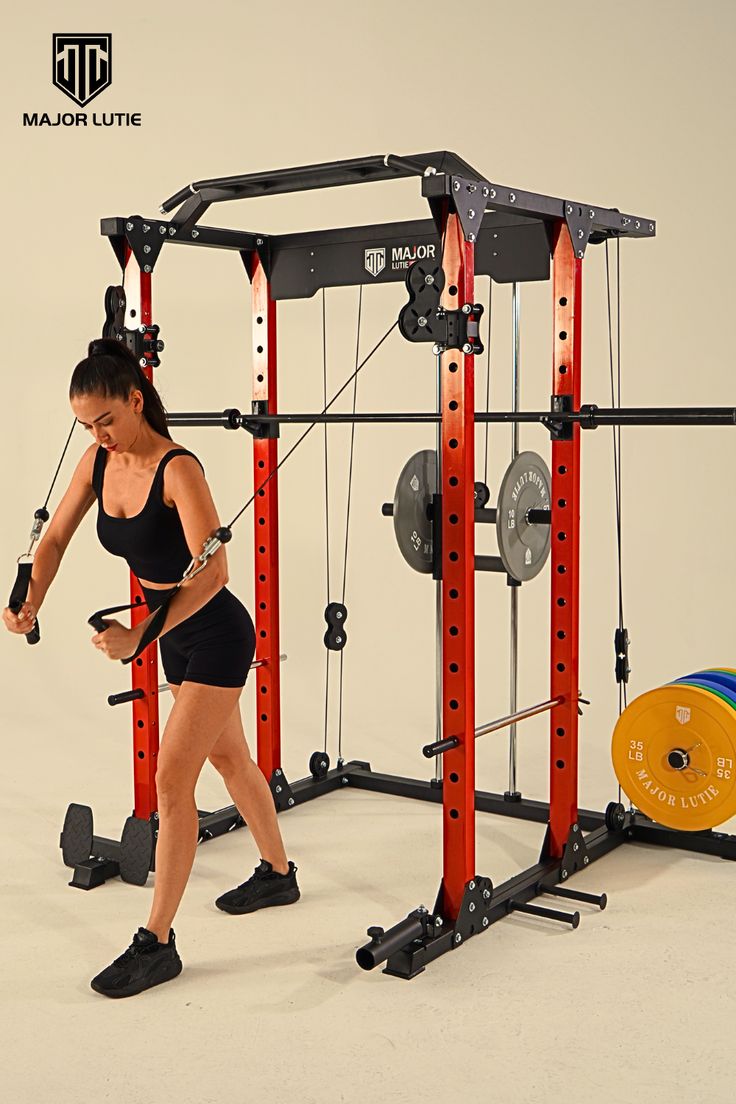 a woman in a black top is working on a pull up bar exercise station with red and black bars