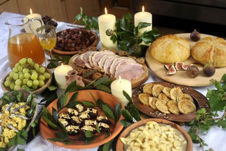 a table topped with lots of different types of food and candles on top of it