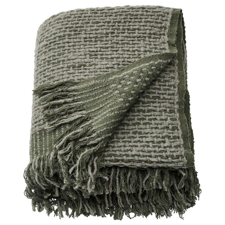 a green and white blanket with fringes