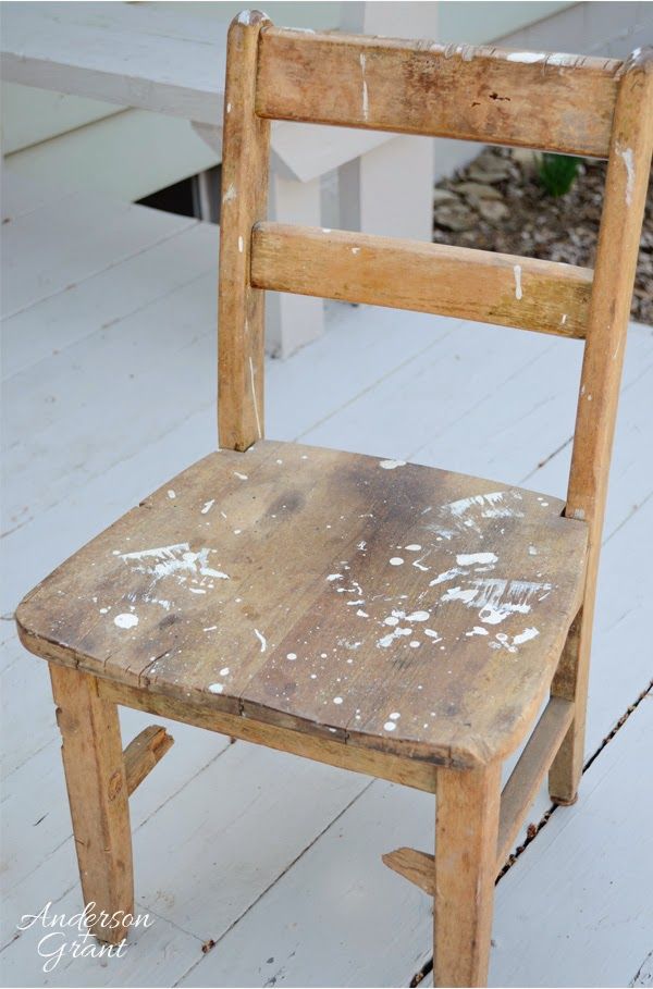 an old wooden chair with white paint on it