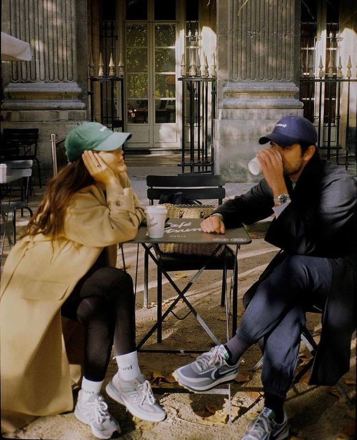 a man sitting next to a woman on top of a chair in front of a building