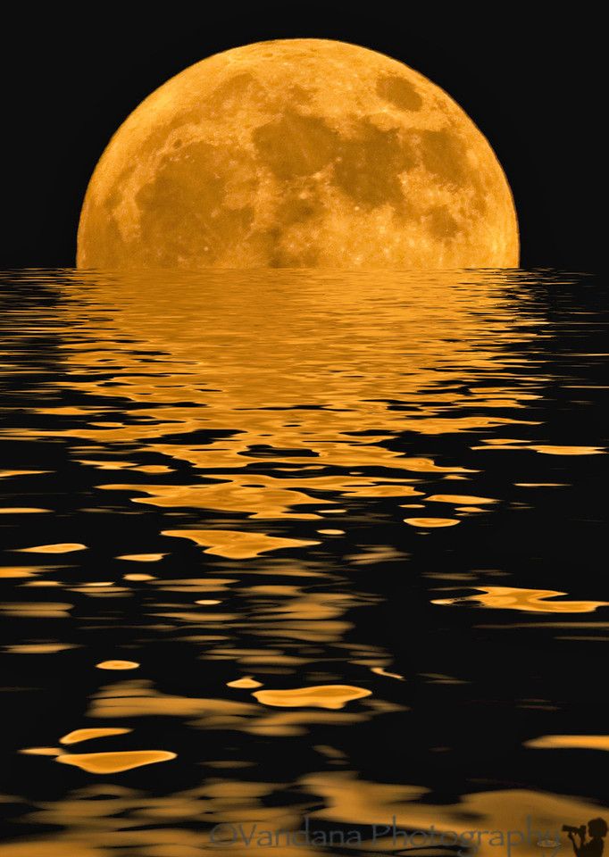 a full moon is reflected in the water