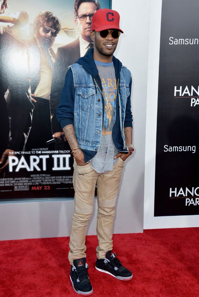 a man standing on top of a red carpet next to a poster for the hangover