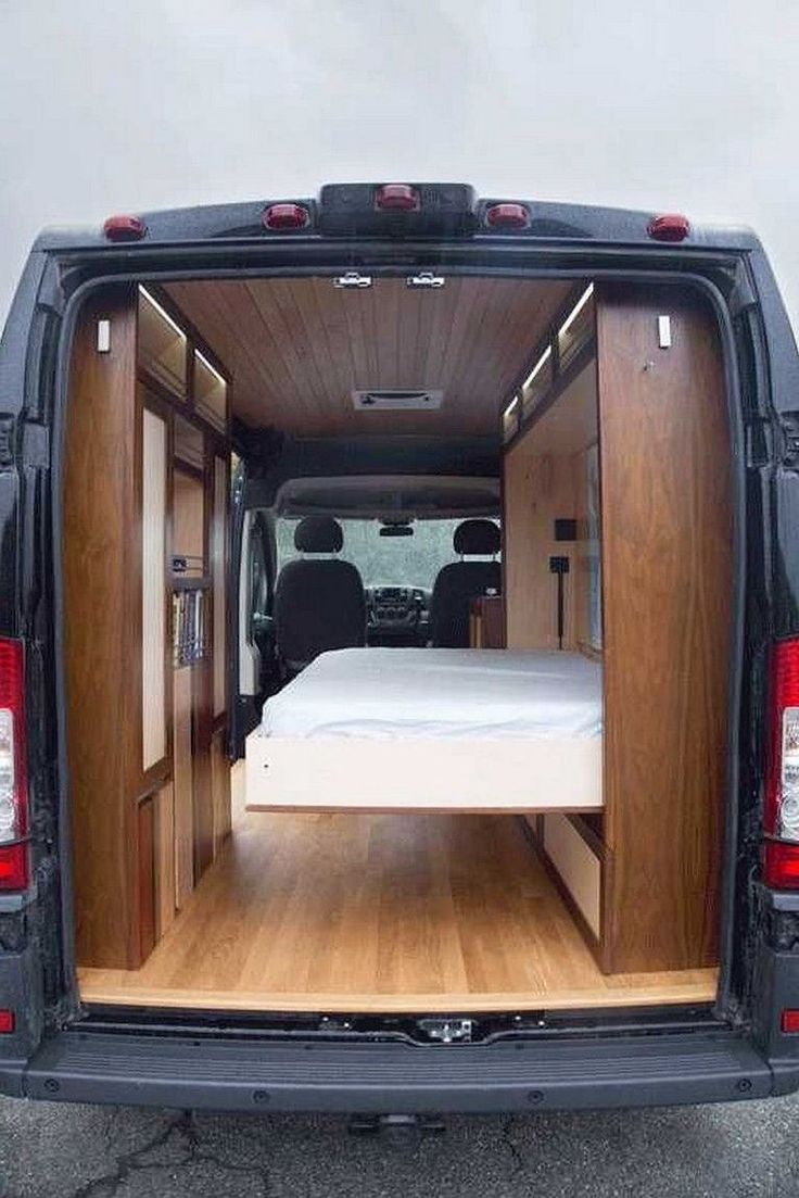 the back end of a van that has a bed in it