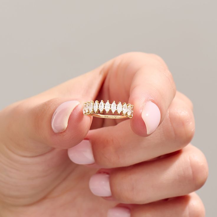 a woman's hand holding a gold diamond ring