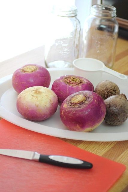 some beets are sitting on a plate next to a knife