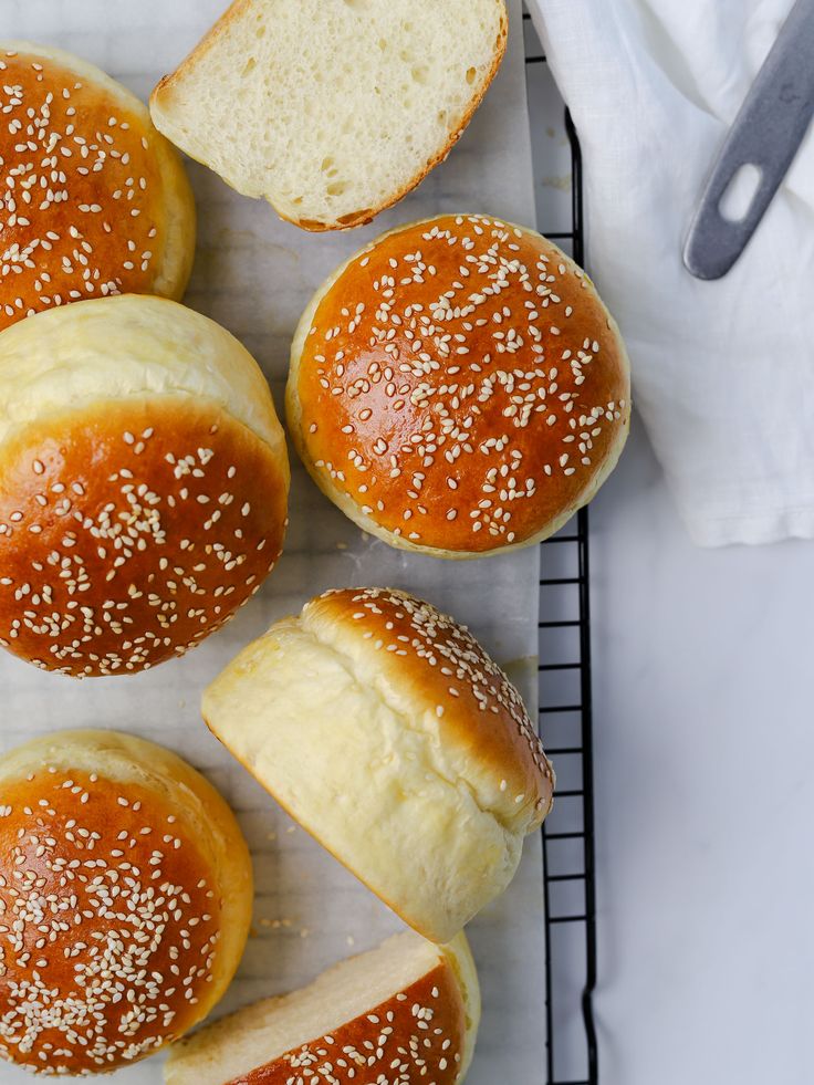 bread buns with sesame seeds and butter on a cooling rack