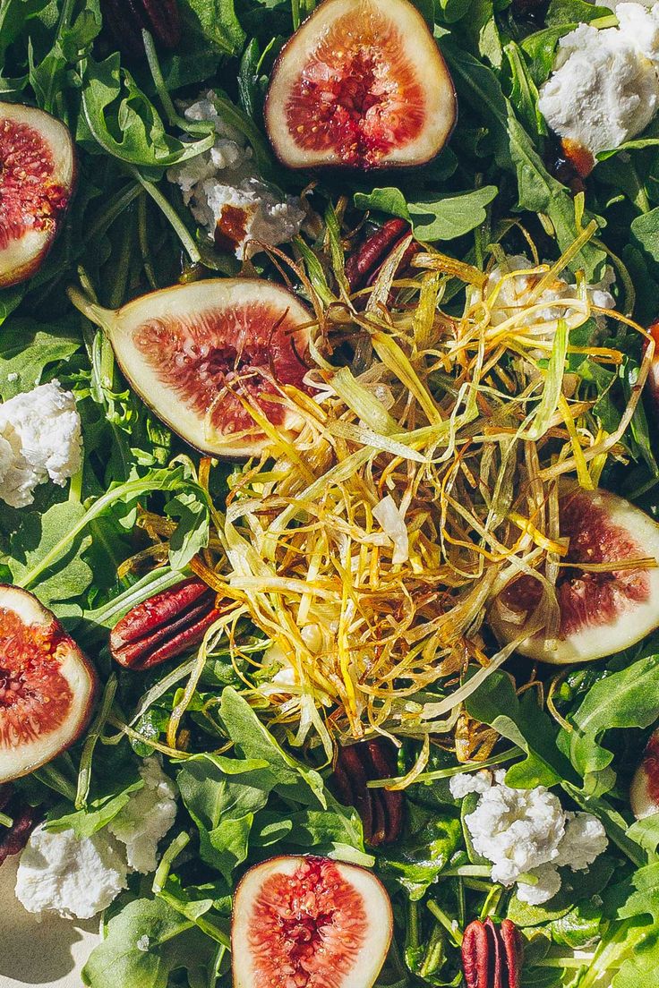 an overhead view of a salad with figs and nuts