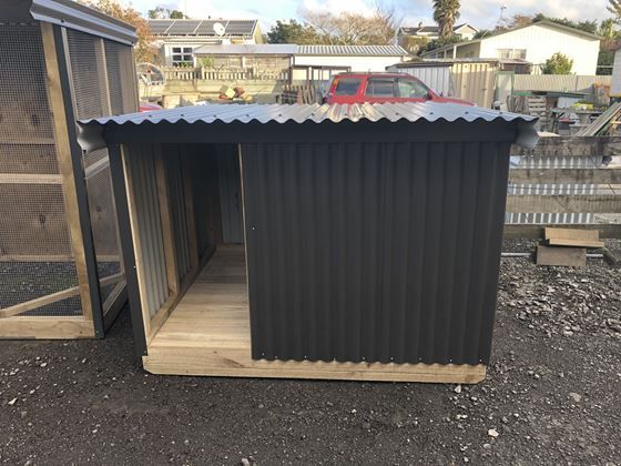 an outhouse with a car parked in the background