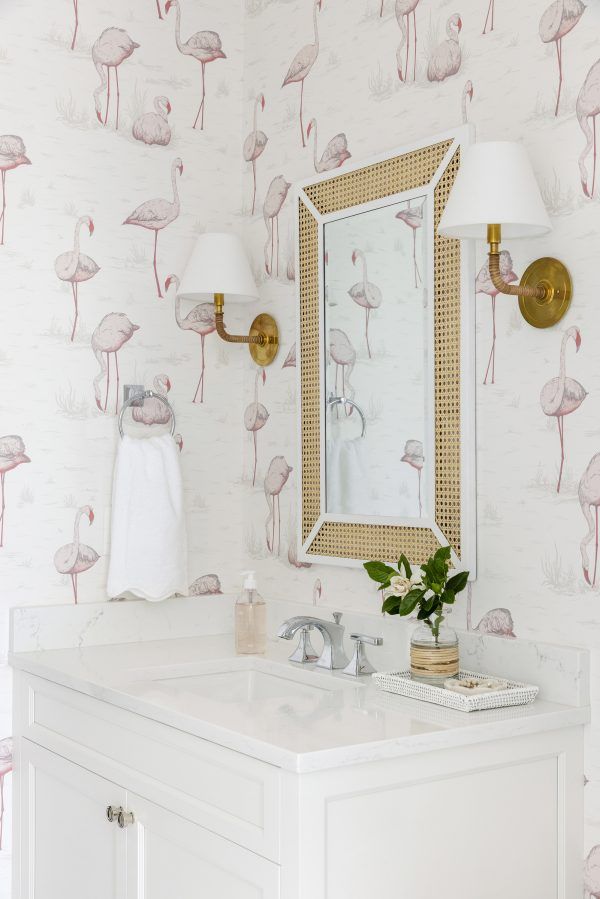 a bathroom with flamingos on the wall and a mirror over the sink in front of it