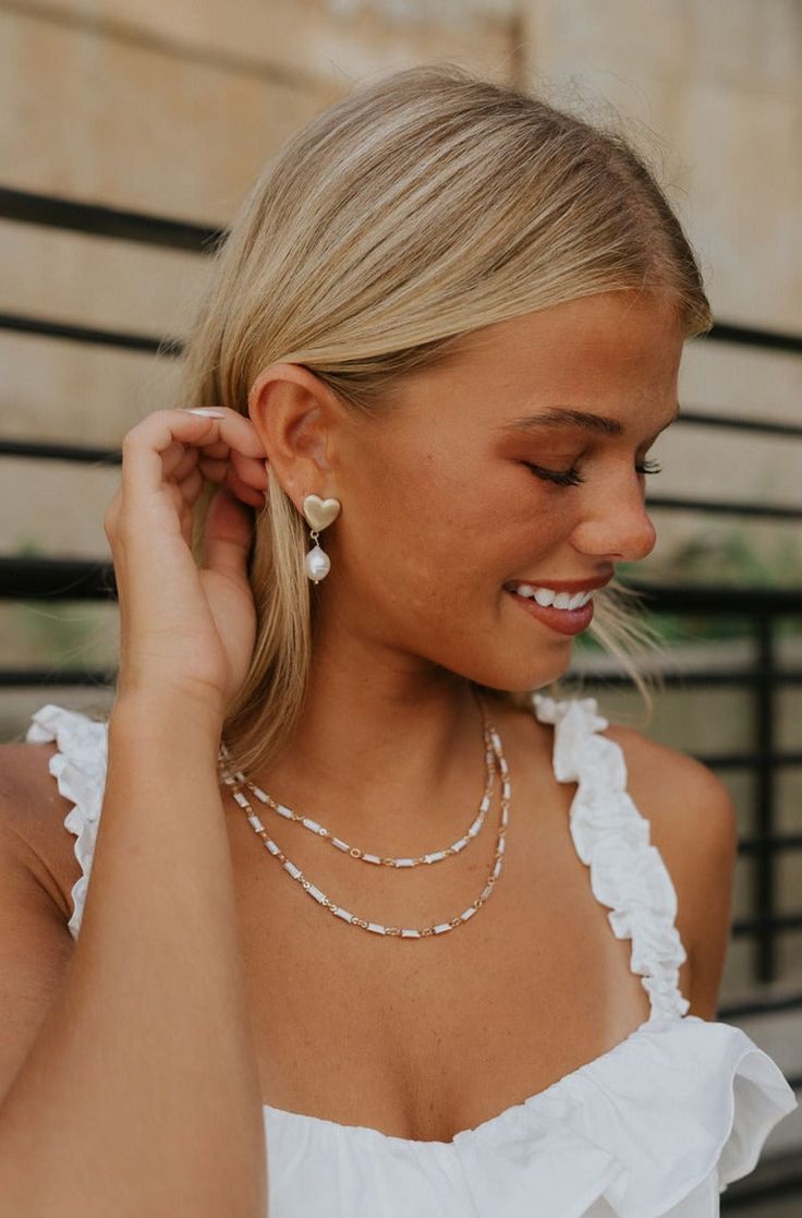 Side view of a model earing the Odessa Pearl Earrings. Beauty And Grace, Love And Affection, Faux Leather Purse, Studded Necklace, Travel Dress, Faux Leather Belts, Hair Fragrance, Bar Earrings, Odessa