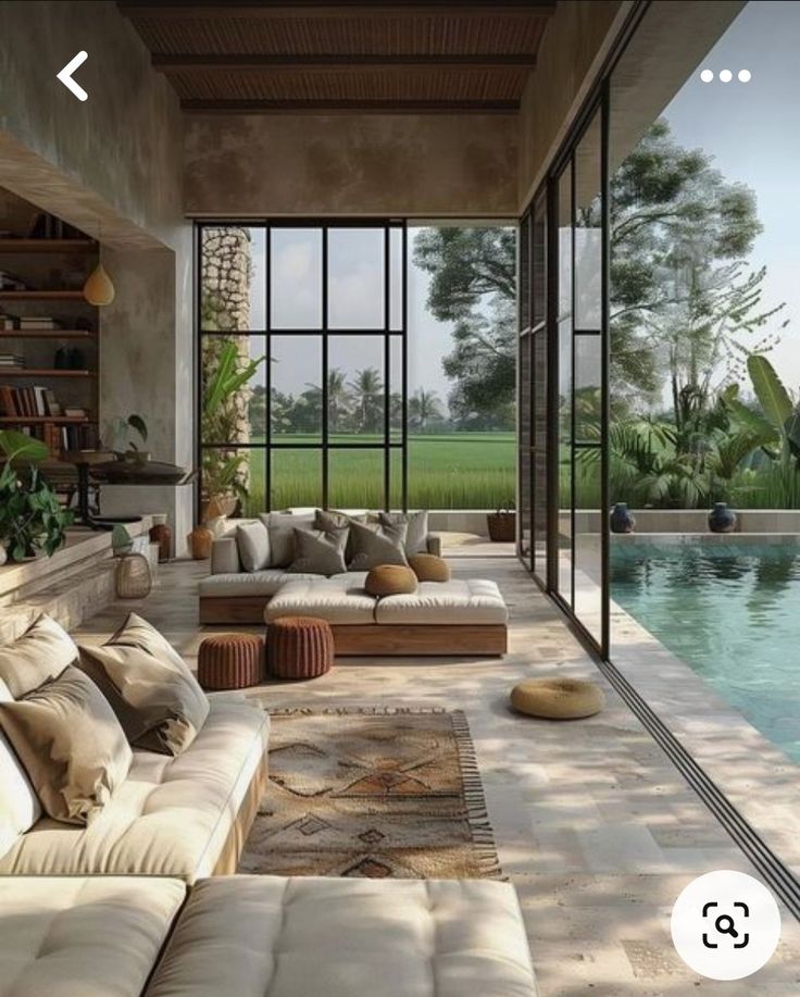 a living room filled with furniture next to a swimming pool