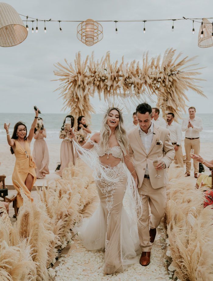 a bride and groom walk down the aisle at their wedding ceremony on the beach in mexico