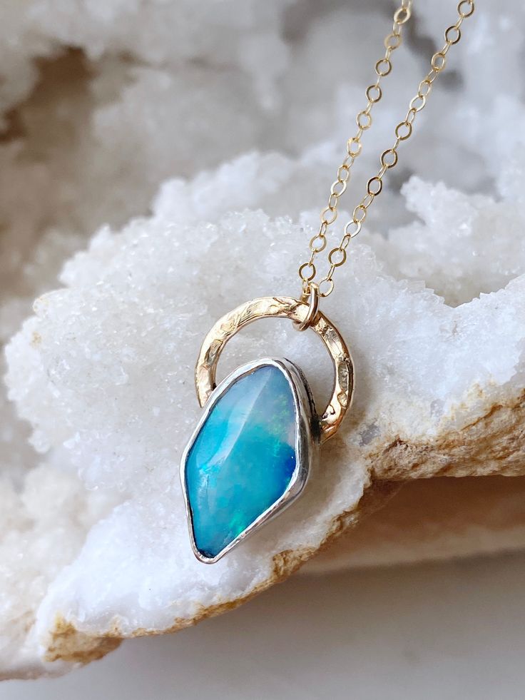 "Fairy-dusted green and blue fire ignites the surface of this gorgeous Australian opal. It's such a energetic, happy range of colors, but the pattern offers a lovely softness to the stone. Set in 14k gold fill. Stone: Australian Opal Setting: 14k gold fill Length: 18\"	is_active	8003065	Apparel & Accessories > Jewelry > Necklaces	https://www.etsy.com/listing/1373885942/australian-opal-necklace	jewelry > necklaces > crystal_necklaces	https://i.etsystatic.com/8003065/r/il/0683ec/4497167454/il_full Unique Blue Necklace With Polished Finish, Hand-forged Blue Jewelry Gift, Blue Opal Pendant Jewelry, Blue Fusion Pendant Jewelry, Fine Jewelry Blue Polished Finish Jewelry, Hallmarked Blue Opal Jewelry, Fusion Blue Gemstone Jewelry, Blue Gemstone Fusion Jewelry, Blue Fusion Jewelry With Gemstone