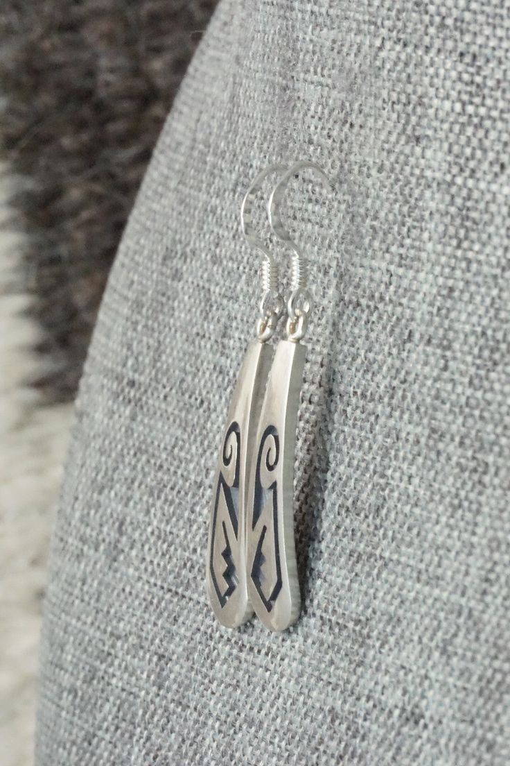 These sterling silver earrings were made by Hopi silversmith Augustine Mowa. The back is stamped sterling.Length: 1 5/8"Width: 1/4"Free shipping on all orders! We ship with USPS and always include tracking. All orders ship within a day of payment.Returns are accepted up to 30 days after you receive your order. Just send us a message. Our shop offers cash back or store credit. The item must be returned in new condition. Sterling Silver Jewelry With Inlay, Engraved Teardrop Sterling Silver Earrings, Elegant Silver Earrings With Inlay, Engraved Sterling Silver Dangle Earrings, Traditional Silver Earrings With Inlay, Artisan Long Drop Silver Earrings, Artisan Long Drop Sterling Silver Earrings, Artisan Silver Long Drop Earrings, Unique Silver Earrings With Inlay