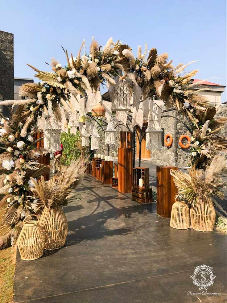 an archway decorated with flowers and feathers