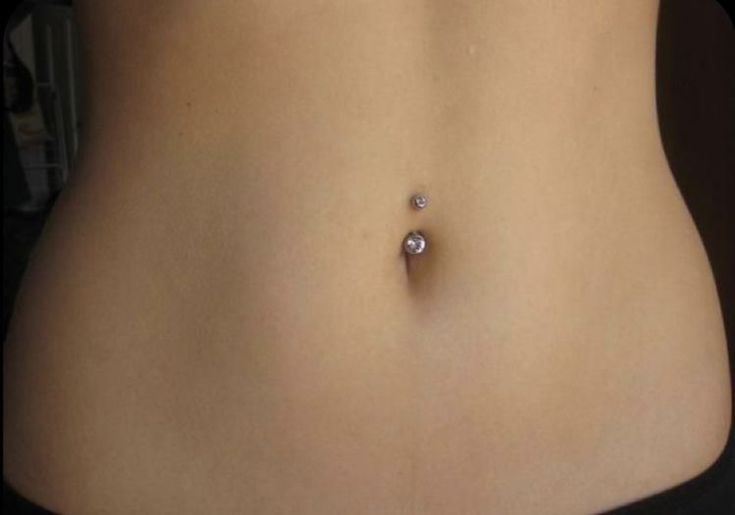 a woman's stomach with a single diamond on it, and the bottom part of her belly visible