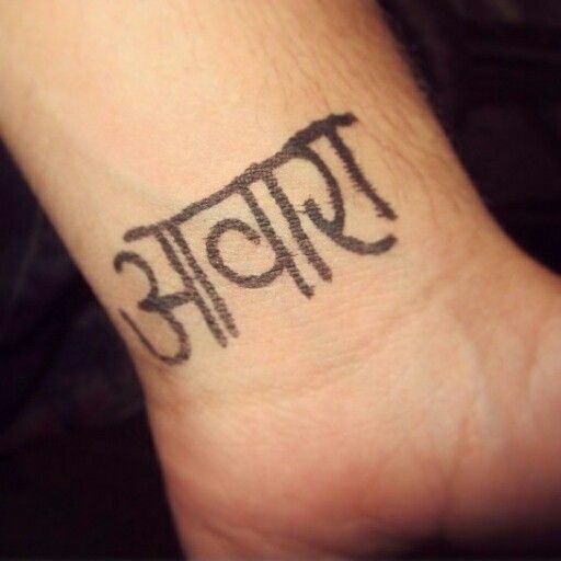 a wrist tattoo with the word buddha written in black ink on it's left side