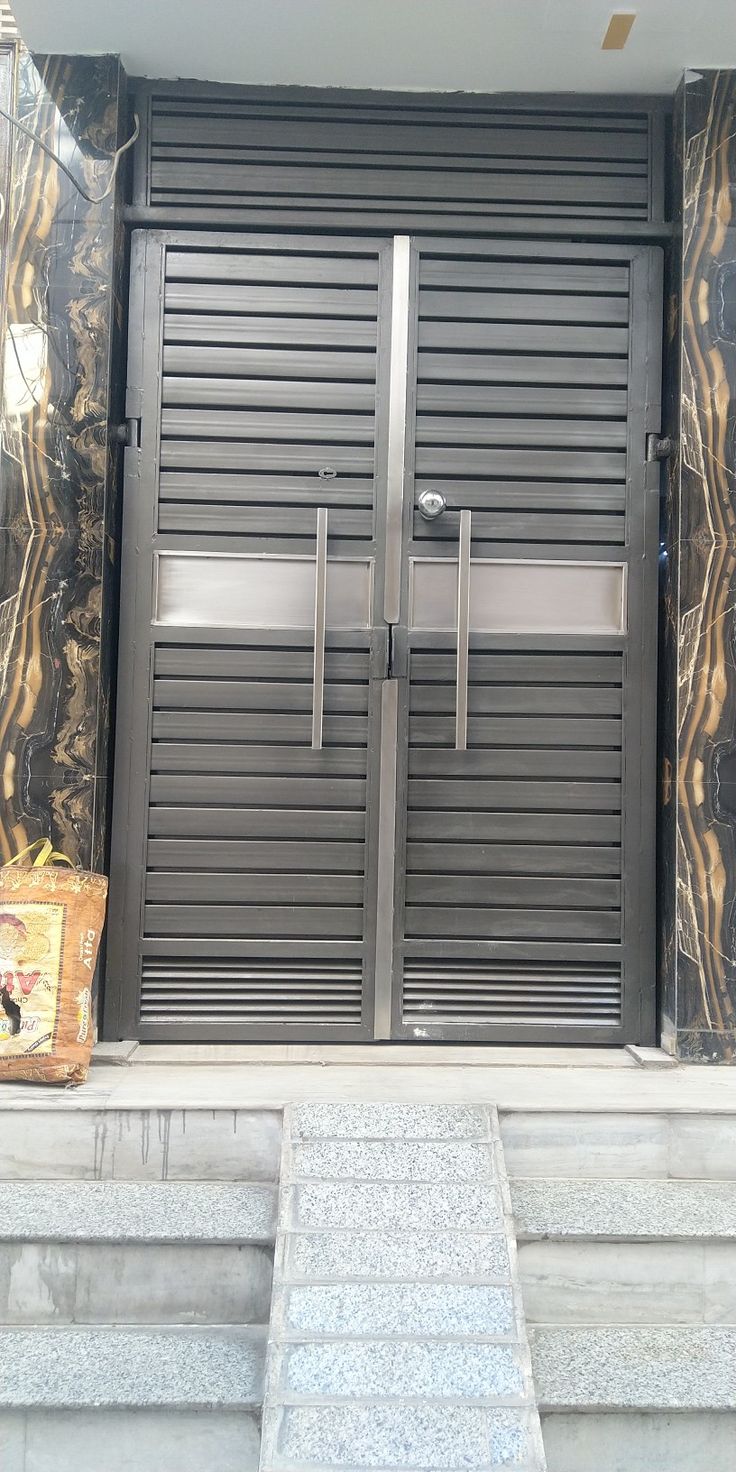 the entrance to an office building with two large doors and steps leading up to it