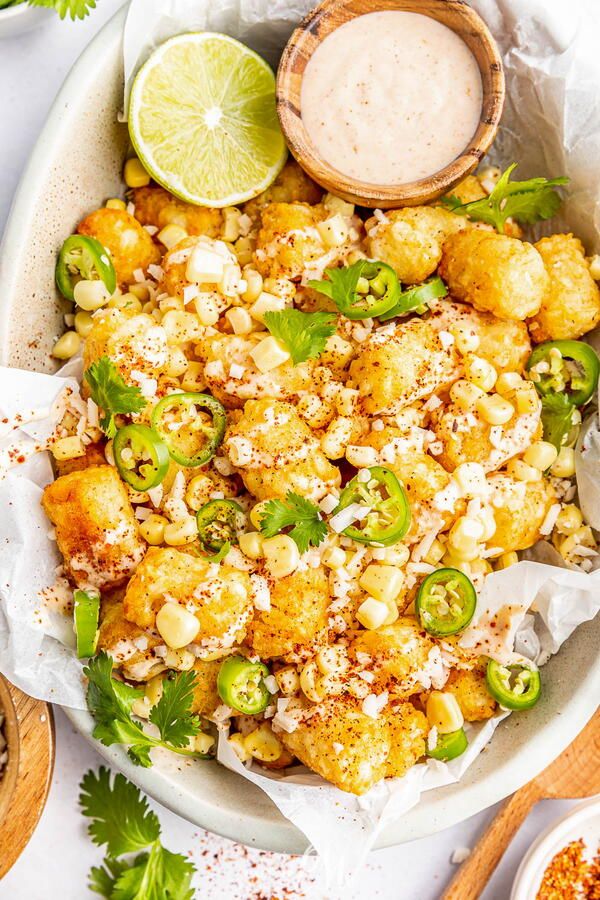 a white bowl filled with fried cauliflower and garnished with cilantro