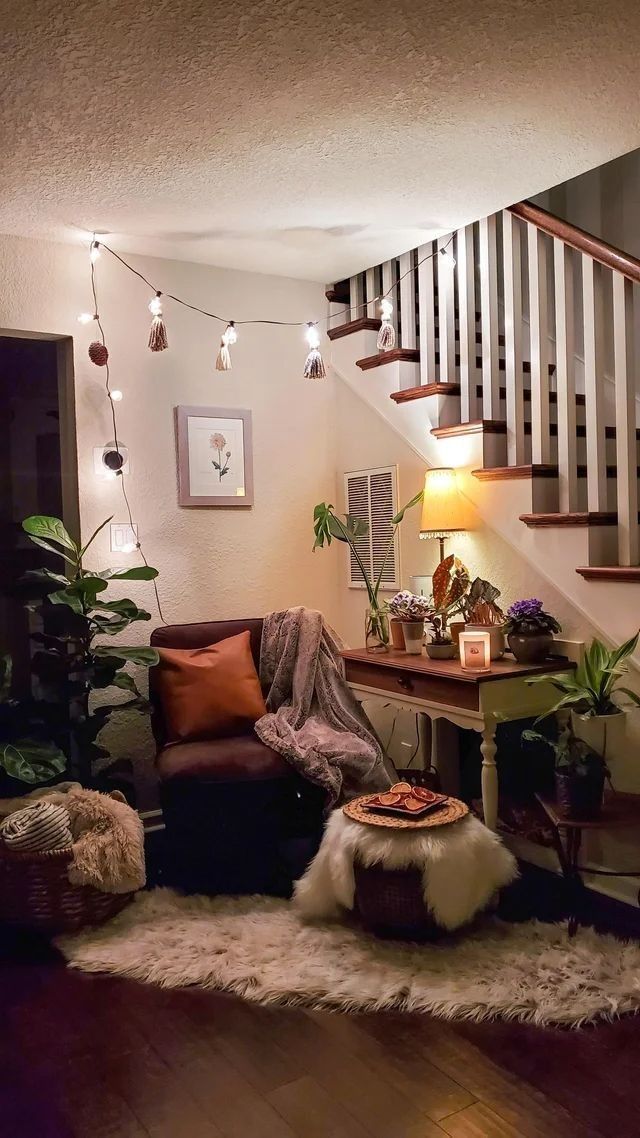 a living room filled with lots of furniture next to a stair case covered in lights