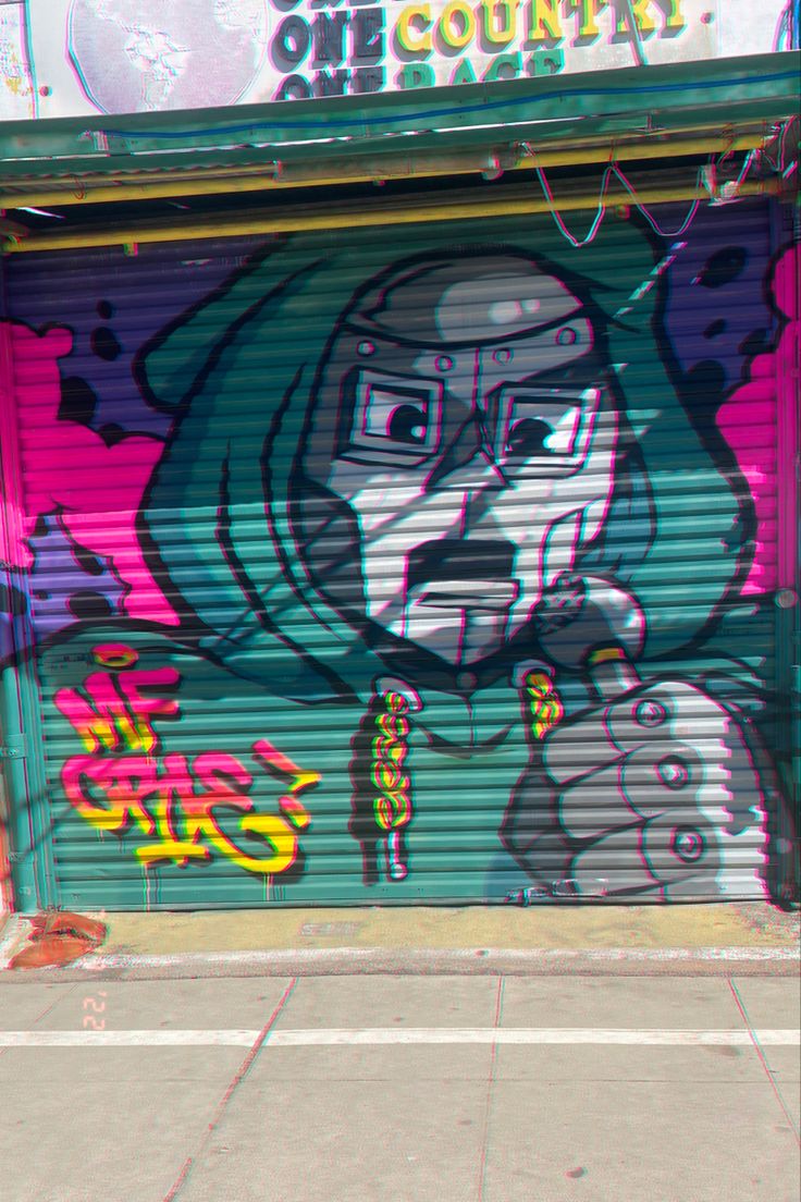 graffiti on the side of a garage door in front of a building with an image of a woman's face