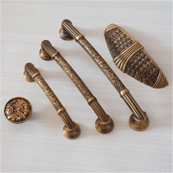 four antique style handles and knobs on a white surface