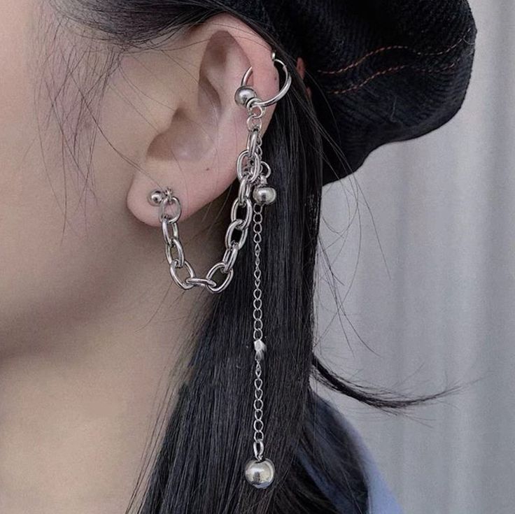 a close up of a person wearing some kind of ear chain with pearls on it