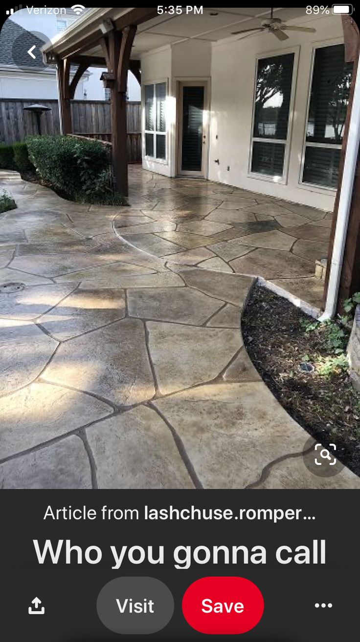 an outdoor patio with flagstone pavers and stone walkway leading to the front door