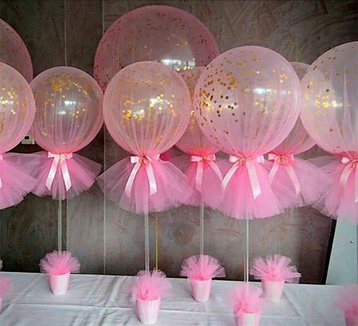 there are many pink balloons on the table