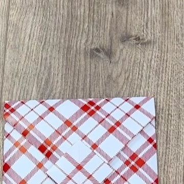 a red and white checkered cloth on a wooden floor with wood grains in the background