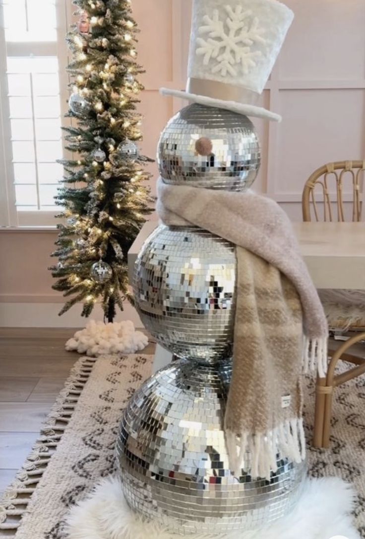 a snowman made out of disco balls and a hat