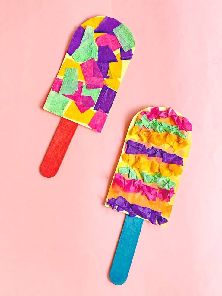 two popsicles decorated with colorful paper and colored crepe on top of each other