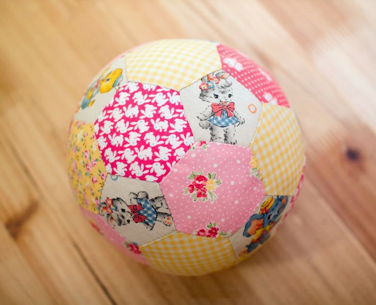 a colorful patchwork ball sitting on top of a wooden floor