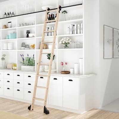 a ladder leaning up against a white bookcase in a room filled with books and vases