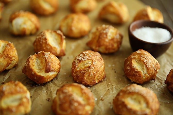 there are many pastries on the baking sheet next to a small bowl of powdered sugar