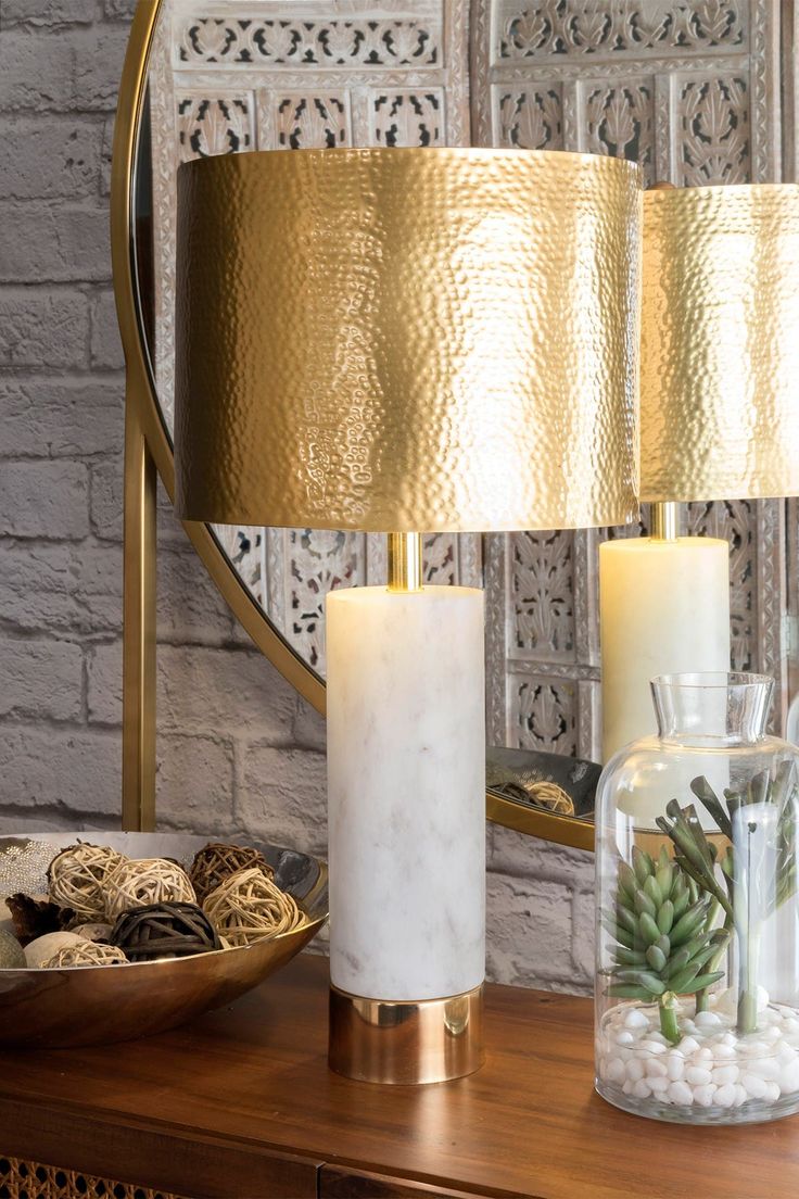 a table topped with a lamp next to a mirror