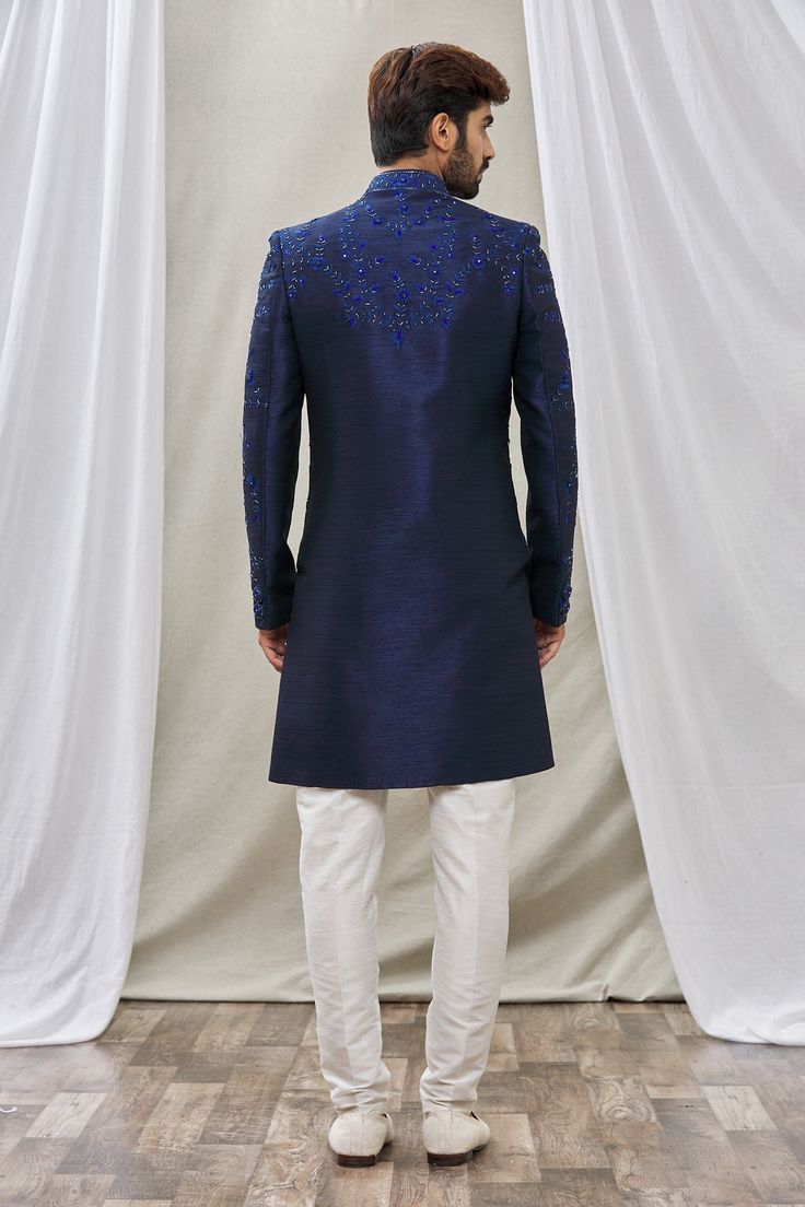 Blue sherwani with floral embroidery and mandarin collar. Paired with pant.
Component: 2
Pattern: Embroidered
Type Of Work: Floral
Neckline: Mandarin
Sleeve Type: Full Sleeves
Fabric: Art Banarasi Silk, Dupion Art Silk
Color: Blue
Other Details: 
Floral embroidery
Front buttons
Note: Pocket square worn by the model is not for sale
Occasion: Sangeet - Aza Fashions Elegant Blue Churidar With Intricate Embroidery, Formal Blue Salwar Kameez With Intricate Embroidery, Blue Semi-stitched Traditional Wear For Formal Occasions, Traditional Blue Unstitched Suit For Formal, Traditional Blue Unstitched Suit For Formal Occasions, Royal Blue Traditional Wear With Dabka For Wedding, Royal Blue Dabka Traditional Wear For Wedding, Blue Nehru Jacket With Dabka For Wedding, Royal Blue Fitted Traditional Wear For Eid