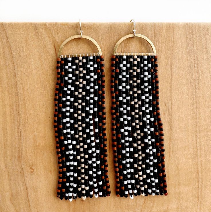 Tvpushnik in the Choctaw language translates to basket. This design is inspired by traditional Choctaw river cane basketry. These hand-beaded earrings with an unfinished open half-round brass top have thirteen fringes with a basket weave diamond motif. Tvpushnik contains 676 delicate glass beads in each earring and is 3" long tradition gloss black, white, neon red, matte turquoise on sterling silver-plated findings, sterling silver ear wires flora gloss forest green, deep pink, eucalyptus, on ra Traditional Black Woven Jewelry, Traditional Woven Dangle Jewelry, Traditional Brown Handwoven Beaded Earrings, Traditional Brown Beaded Fringe Earrings, Traditional Woven Jewelry In Natural Color, Traditional Handwoven Brown Earrings, Traditional Brown Handwoven Earrings, Traditional Woven Natural Jewelry, Traditional Woven Natural Color Jewelry